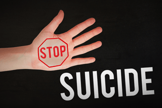 Hand with red stop sign and the word suicide, mental health awareness concept