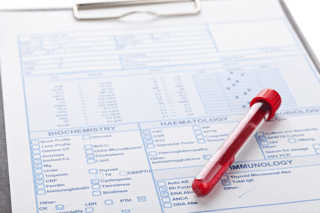Blood sample tube on functional lab test form for biochemistry, hematology, immunology analysis
