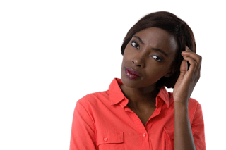 Woman in coral shirt looking confused, hand to head, symbolizing hypothyroidism symptoms